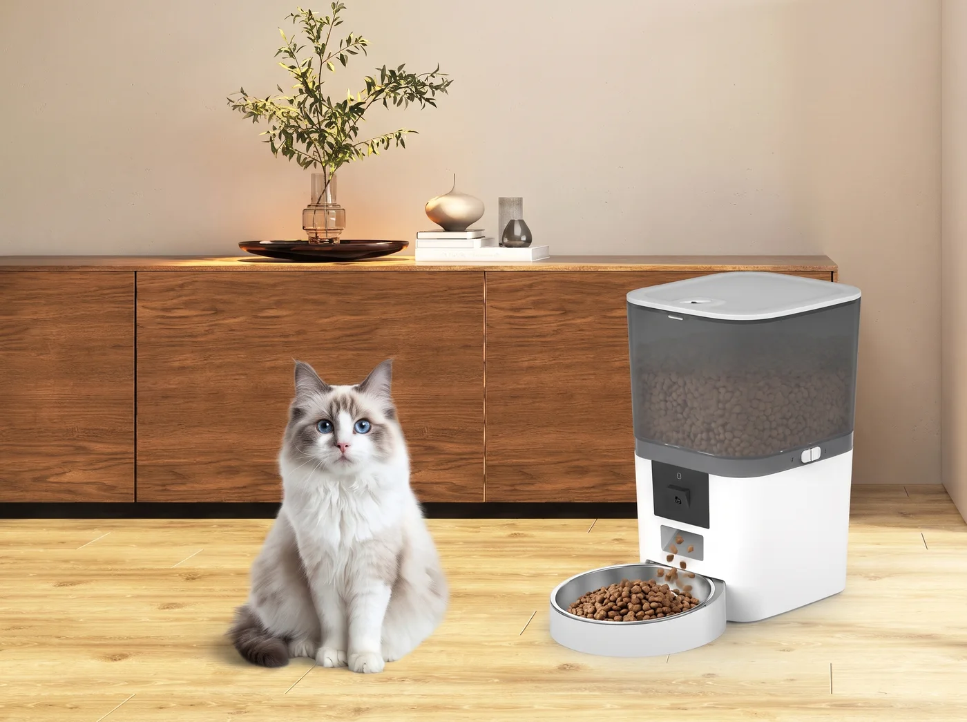 Een kat zit in de woonkamer naast de witte voerautomaat